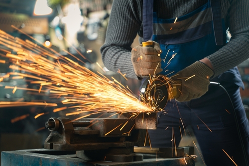 A man grinding metal with a grinder